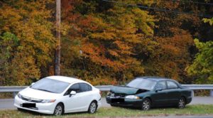 Car accident scene depicting the dangers of distracted driving with a smartphone visible, emphasizing the importance of focused driving in Pasadena, MD. Huff Insurance, Insurance Agent in Pasadena Maryland